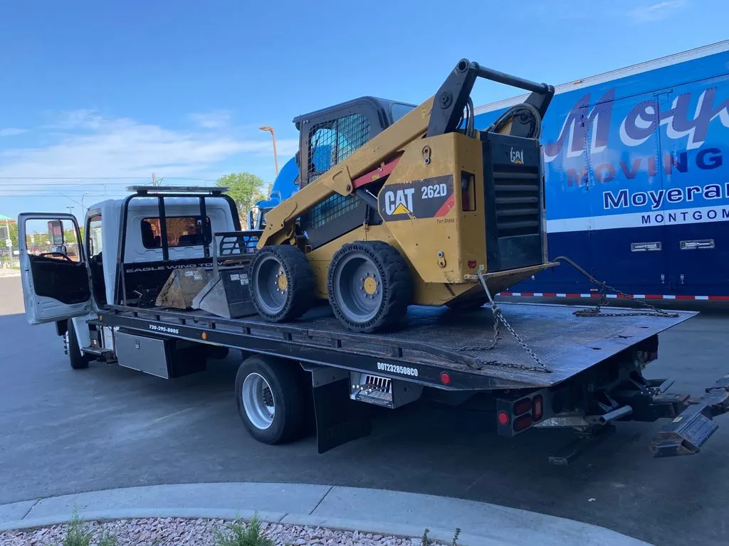 Cat skidster in back of Eagle wing Towing of aurora, CO flatbed