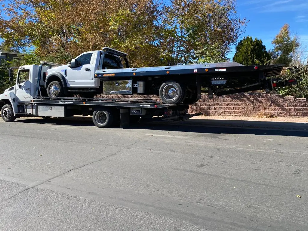 White heavy duty tow truck towing another tow truck