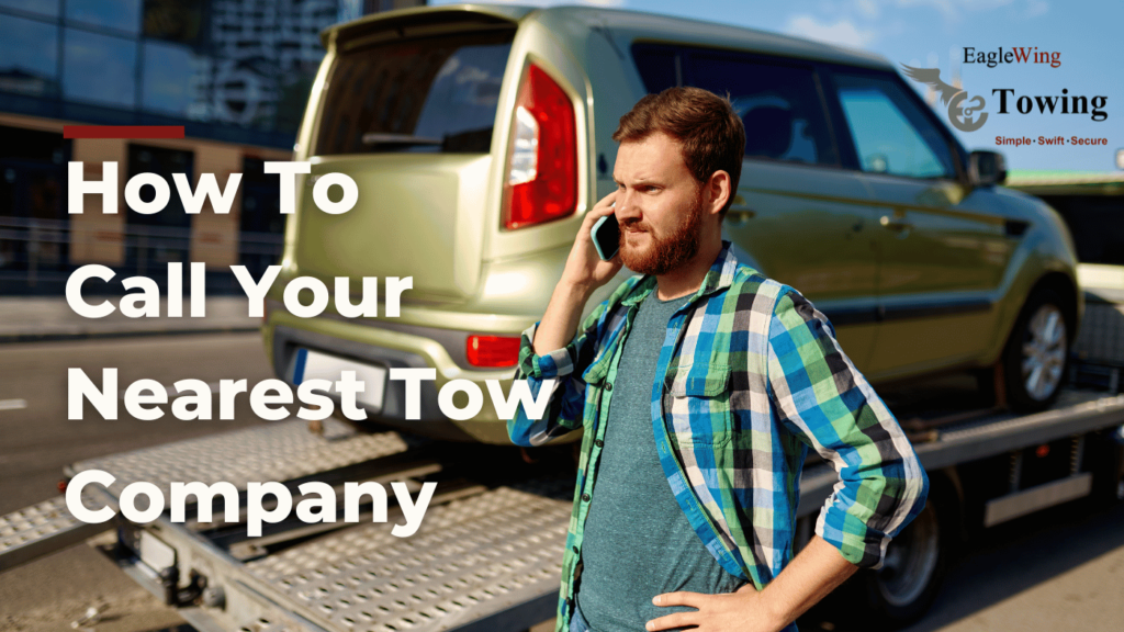 A man calling a towing company while standing next to his car being loaded onto a tow truck by Eagle Wing Towing.